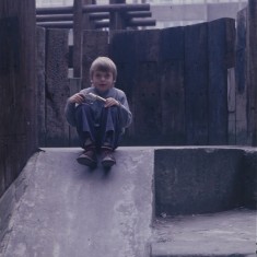 Boy sitting in Broomhall Flats play area. July 1978 | Photo: Tony Allwright